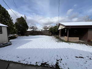 Yard covered in snow featuring fence