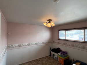 Interior space featuring a chandelier, wainscoting, and ornamental molding