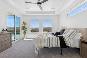 Bedroom with access to outside, a tray ceiling, carpet flooring, a ceiling fan, and recessed lighting