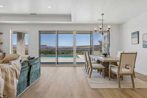 Dining space with a chandelier, light wood-type flooring, plenty of natural light, and recessed lighting