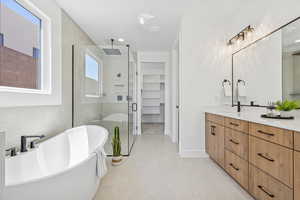 Full bath with a stall shower, double vanity, a freestanding tub, tile patterned flooring, and a spacious closet