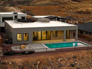 Back of property with an outdoor fire pit, a patio area, and stucco siding