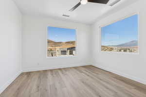 Empty room with wood finished floors and ceiling fan
