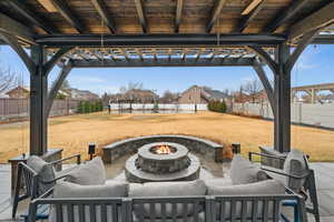 View of patio / terrace featuring an outdoor living space with a fire pit, a fenced backyard, and a pergola