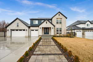 View of front of house featuring driveway, fence, and a front lawn