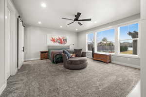 Bedroom with carpet floors, recessed lighting, baseboards, and a barn door