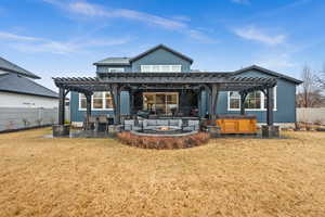 Rear view of house featuring a hot tub, a patio area, a fenced backyard, and a pergola