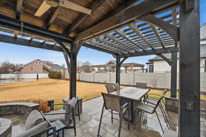 View of patio featuring outdoor dining area, a fenced backyard, a ceiling fan, and a pergola