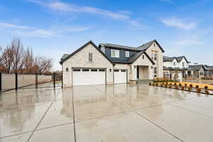 View of front of home featuring concrete driveway, fence, and an attached garage