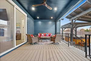 Wooden terrace with ceiling fan, fence, outdoor lounge area, and a pergola