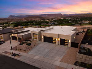 Contemporary home with stucco siding, a mountain view, a garage, and driveway