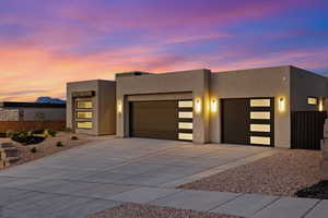 Modern home featuring an attached garage, driveway, and stucco siding