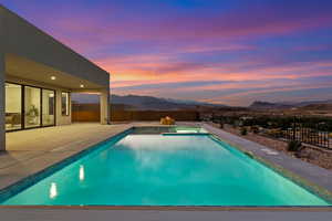 View of pool with a mountain view, a fenced backyard, a patio, and a pool with connected hot tub