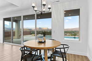 Dining area with wood finished floors, a mountain view, and a chandelier