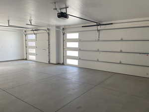 Garage featuring a garage door opener and baseboards
