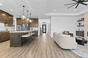 Living room featuring recessed lighting, light wood-type flooring, and a ceiling fan