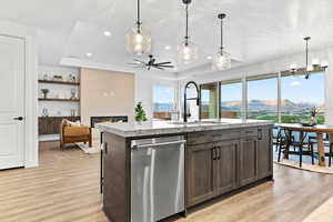 Kitchen featuring dishwasher, a raised ceiling, light wood finished floors, recessed lighting, and a mountain view