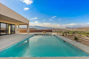 View of pool featuring a mountain view, a fenced backyard, a patio area, and a pool with connected hot tub