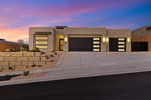 Modern home with an attached garage, stucco siding, and driveway