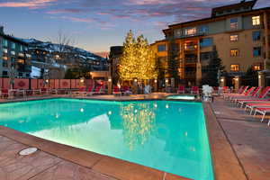 Pool at dusk with a patio and fence