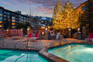 View of pool with a hot tub, fence, and a patio