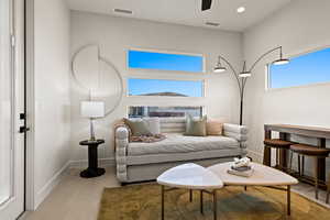 Living area with light tile patterned floors, baseboards, visible vents, and recessed lighting
