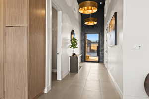 Hallway featuring baseboards and light tile patterned flooring