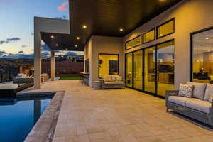 Patio terrace at dusk with fence, an outdoor living space, and a fenced in pool