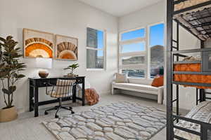 Carpeted office featuring a towering ceiling and baseboards