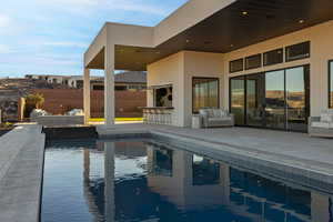 View of swimming pool featuring outdoor lounge area, a patio area, fence, and outdoor dry bar