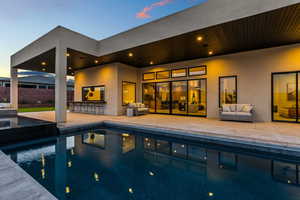 View of swimming pool with a patio area, outdoor dry bar, a fenced in pool, and an outdoor living space