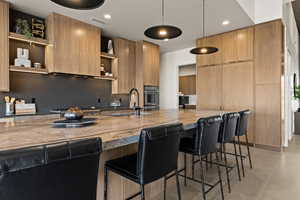 Kitchen featuring stainless steel appliances, modern cabinets, open shelves, and a sink