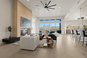 Living room featuring light tile patterned floors, recessed lighting, visible vents, a multi sided fireplace, and baseboards