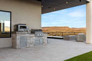 View of patio / terrace featuring area for grilling, an outdoor kitchen, and a mountain view
