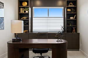 Home office with baseboards and built in features