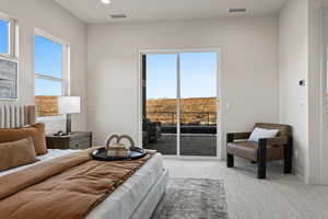 Carpeted bedroom with access to exterior, visible vents, and multiple windows