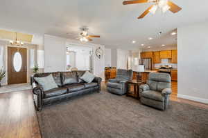 Living area with a textured ceiling, light wood finished floors, a chandelier, and baseboards