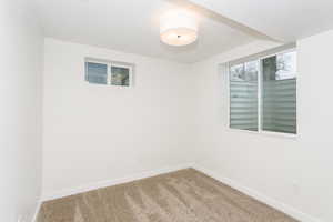 Carpeted empty room featuring baseboards and a textured ceiling