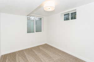 Carpeted empty room with baseboards and a textured ceiling