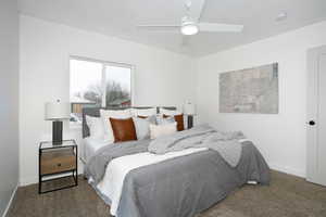 Carpeted bedroom featuring ceiling fan and baseboards