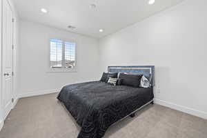 Carpeted bedroom featuring recessed lighting, visible vents, and baseboards