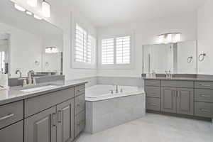 Full bathroom with a garden tub, two vanities, and a sink