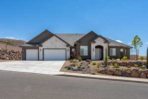 View of front of home with a garage, stone siding, a tile roof, and driveway