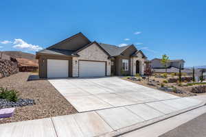 Single story home featuring a garage, concrete driveway, stone siding, a tiled roof, and stucco siding