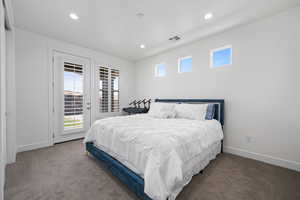 Carpeted bedroom with baseboards, recessed lighting, visible vents, and access to exterior