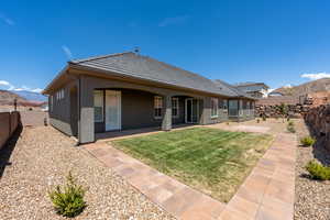 Rear view of property featuring a fenced backyard, a mountain view, a lawn, and stucco siding