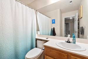 Bathroom with visible vents, vanity, and toilet
