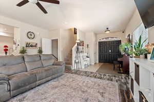 Living room featuring ceiling fan, stairway, and wood finished floors
