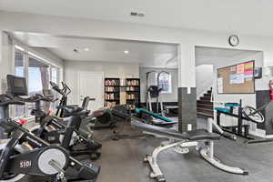 Gym with baseboards, visible vents, a wealth of natural light, and recessed lighting