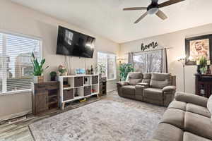 Living room with a ceiling fan, baseboards, and wood finished floors